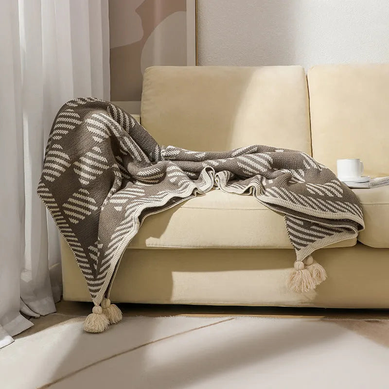 Acrylic sofa blanket with tassels in geometric pattern colour option on a sofa