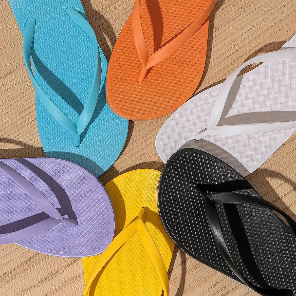 Foldable flat beach slipper with non-slip PVC sole and hollow-out plastic upper in orange colour.