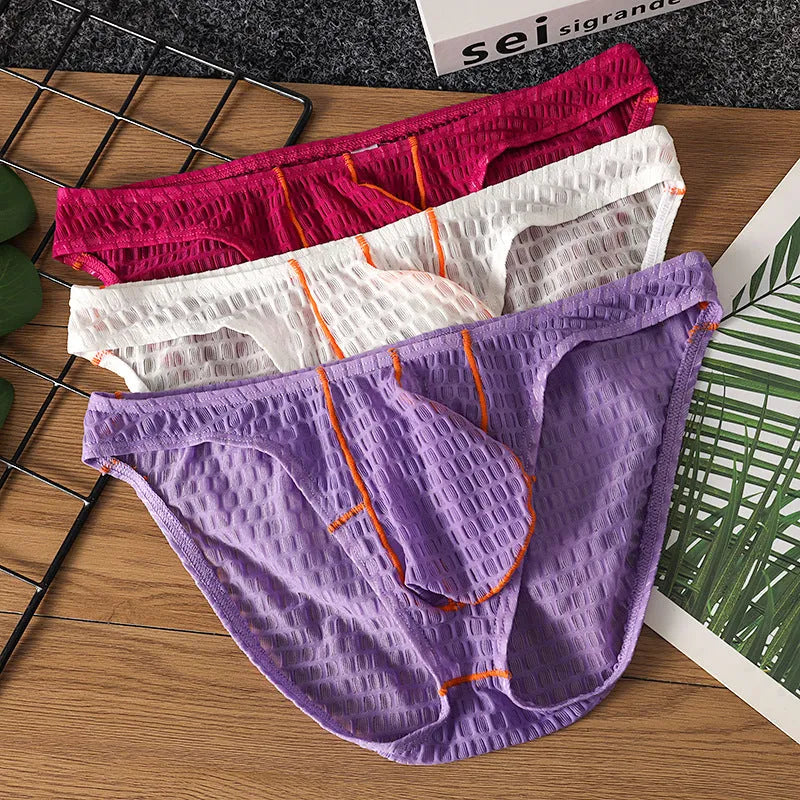 Men's low-waist lace briefs in white, black, green, red, and purple colours laid flat.