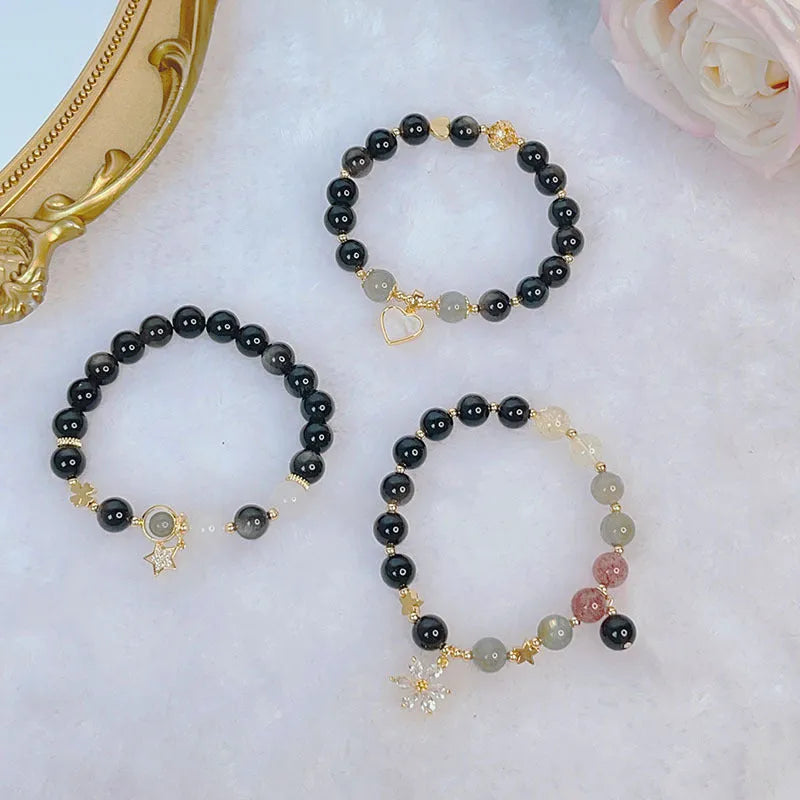 Adjustable silver stone bracelet for women with choice of flower, love, or star charm on a white background.
