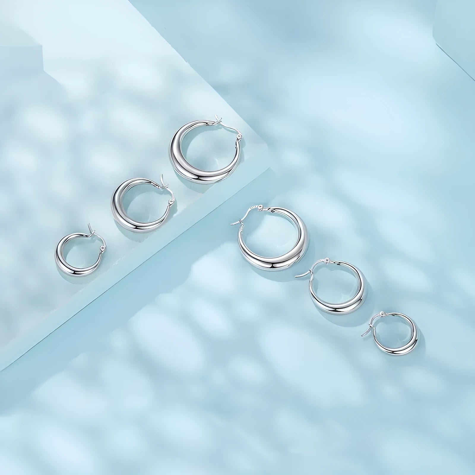 Women's geometric ring clip earrings in silver finish, available in three sizes