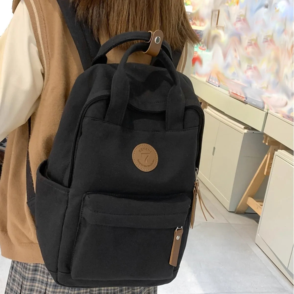 Black Oxford cloth fashion backpack with curved shoulder straps and retro sewing thread details