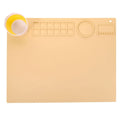 Light blue silicone painting mat with two mixing bowls, measuring 50cm by 40cm on a wooden table.