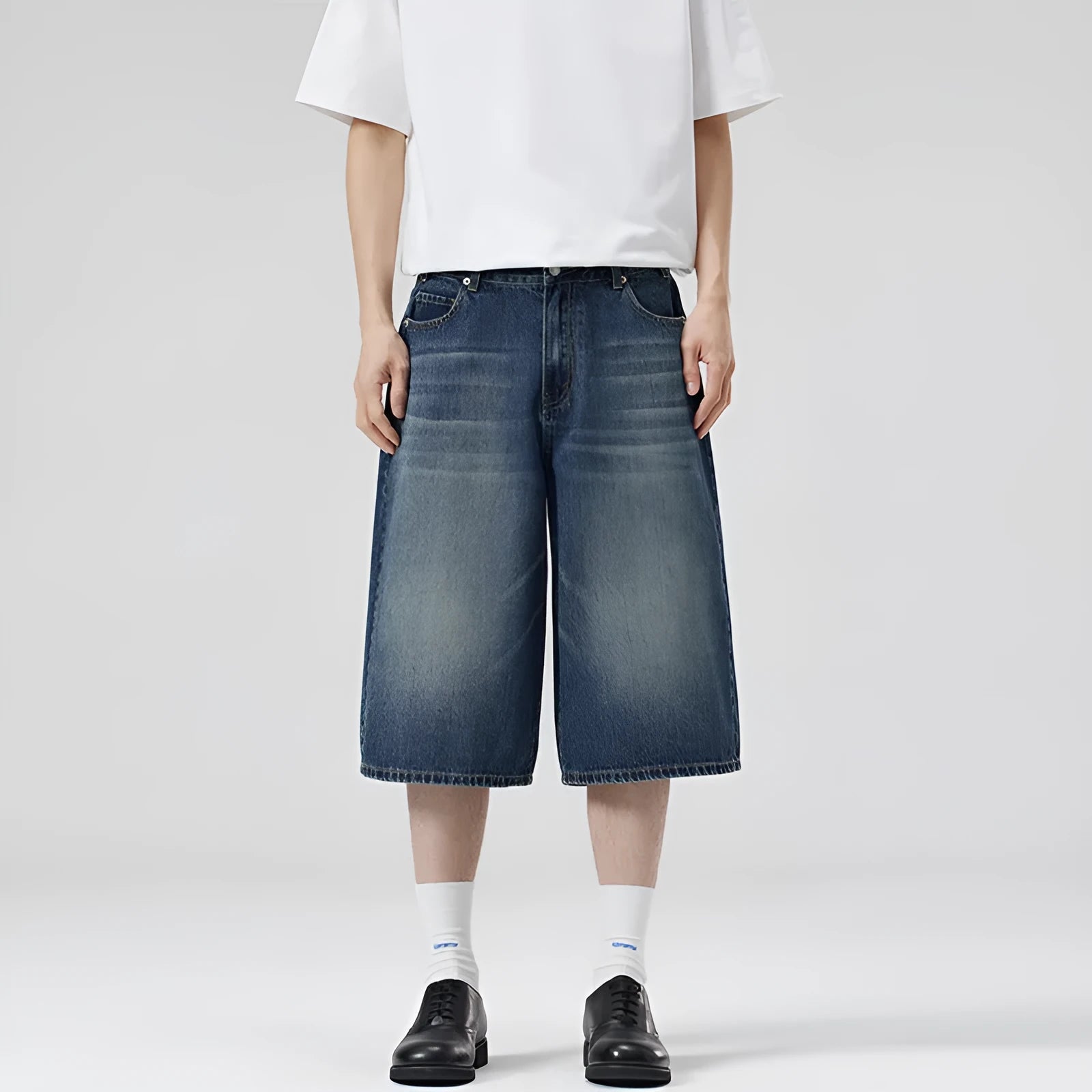 Man wearing straight-leg light blue denim shorts, showcasing the cropped length and loose casual fit.