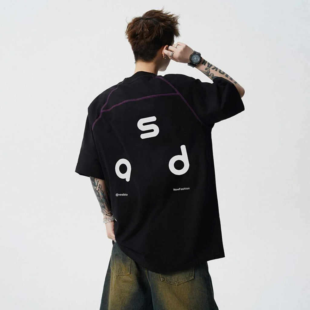 Man wearing a loose-fit black cotton t-shirt with a white letter print on the chest.