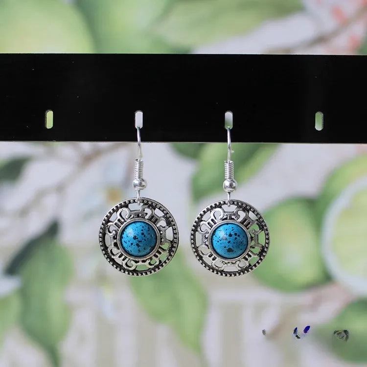 Handmade geometric flower disk earrings in Tibetan silver and turquoise with auspicious cloud patterns.