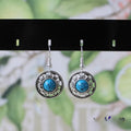 Handmade geometric flower disk earrings in Tibetan silver and turquoise with auspicious cloud patterns.