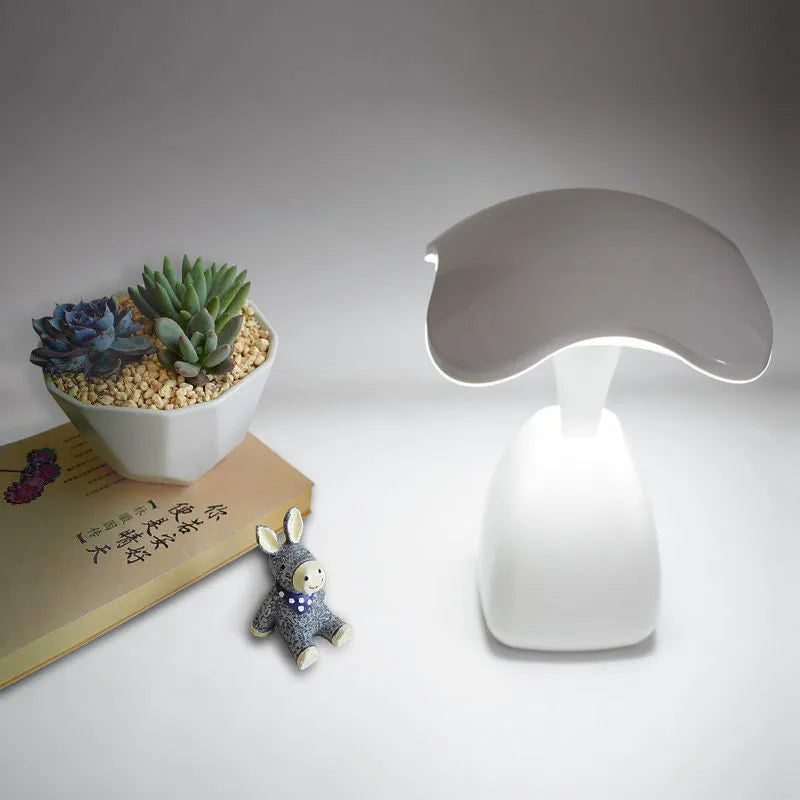 White modern plastic LED desk lamp with touch control on a wooden surface.