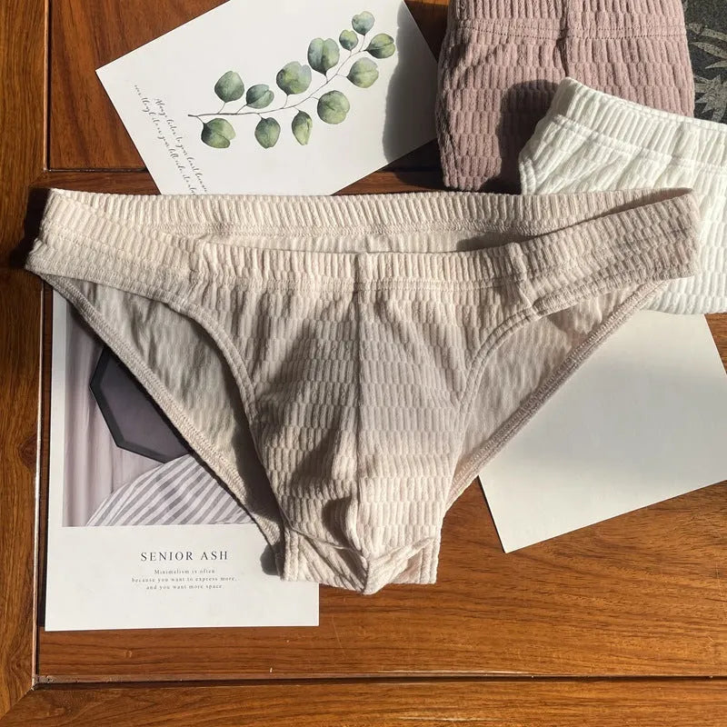 Men's solid colour cotton triangle briefs in mid-waist style, shown in apricot and black colour options.