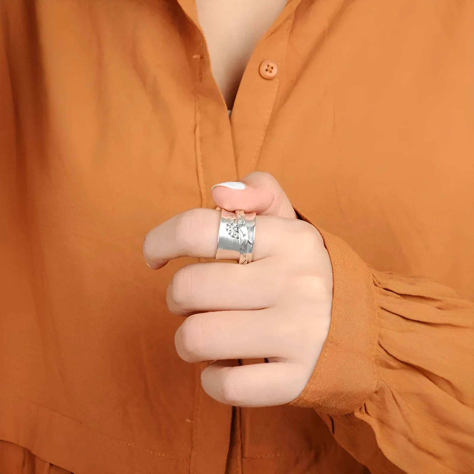 Silver colour rotatable flower ring on finger showing floral centrepiece