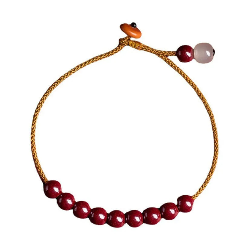 Close-up of a hand-woven geometric bracelet made from cinnabar and Hetian jade stones.