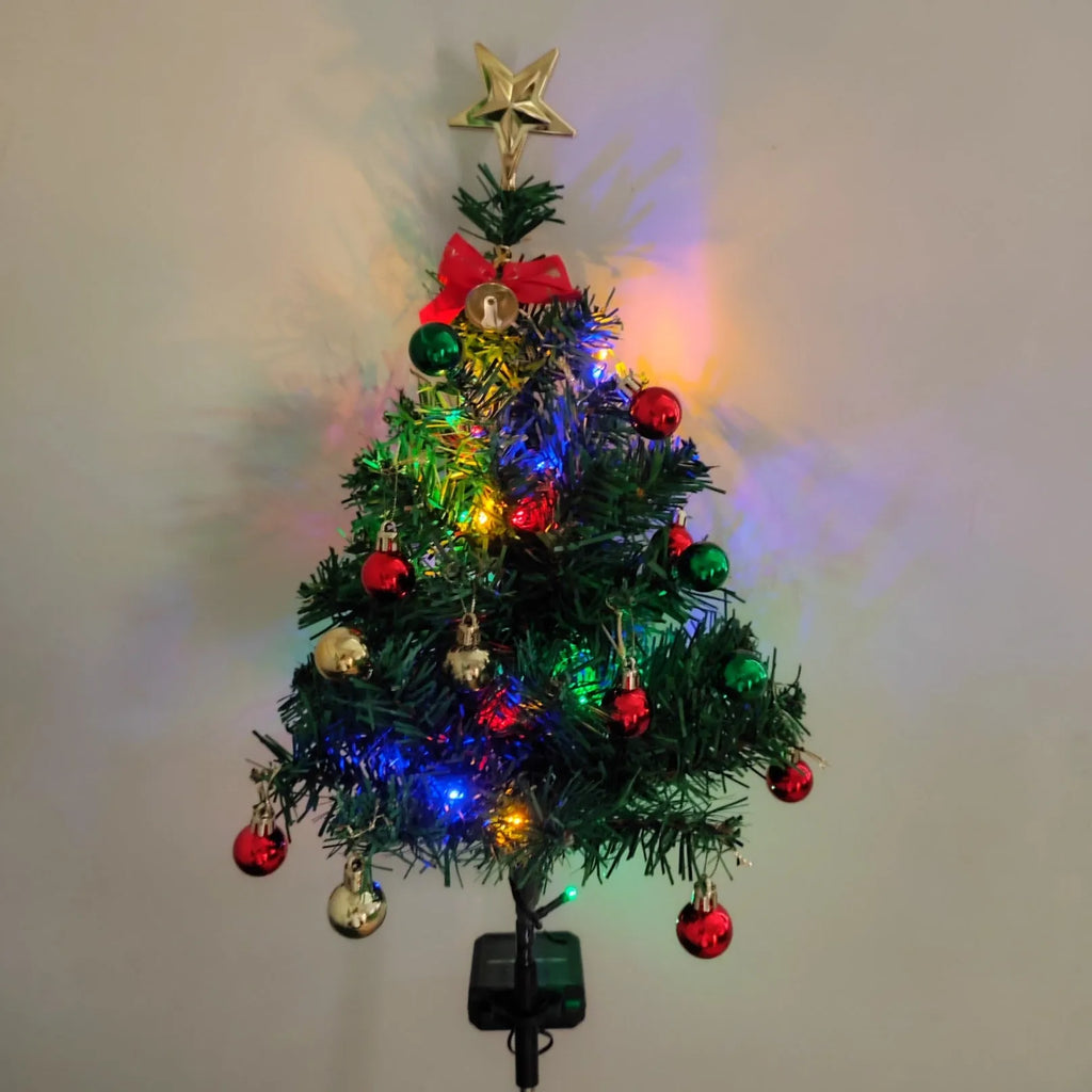 Solar Christmas tree lamp with ABS body placed on grass in a garden setting