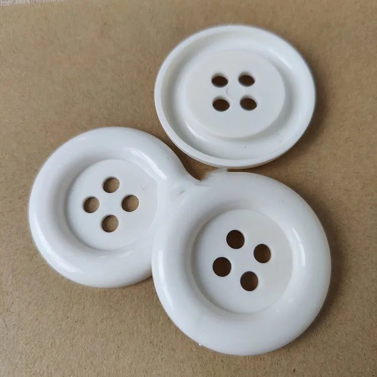 Oversized round plastic sewing buttons in multiple colours with four holes