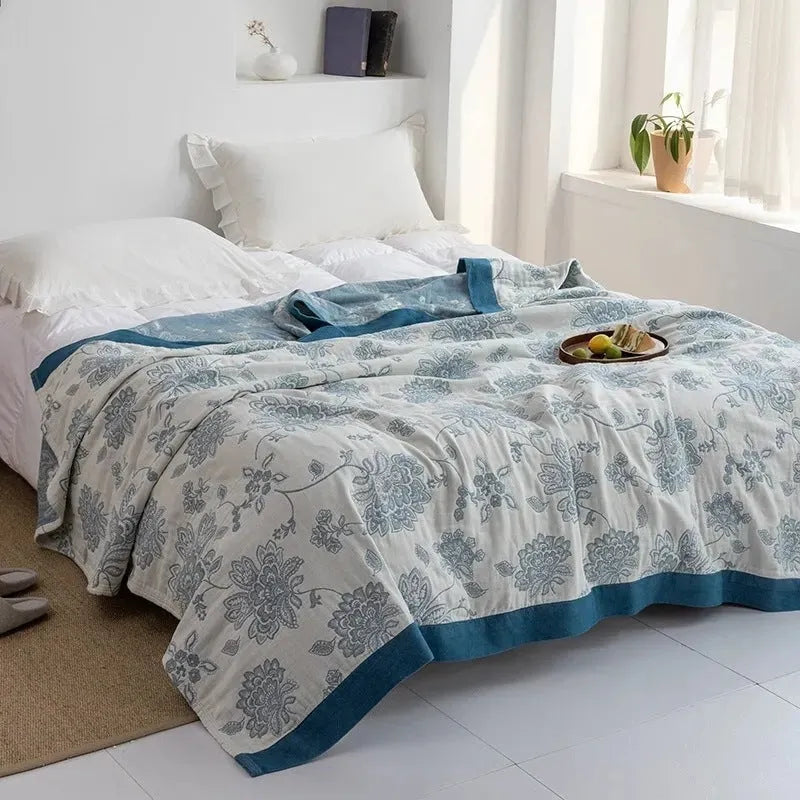 Roulette Wheel Blue five-layer gauze cotton bed blanket on a bed, showing Modern Simplicity pattern.