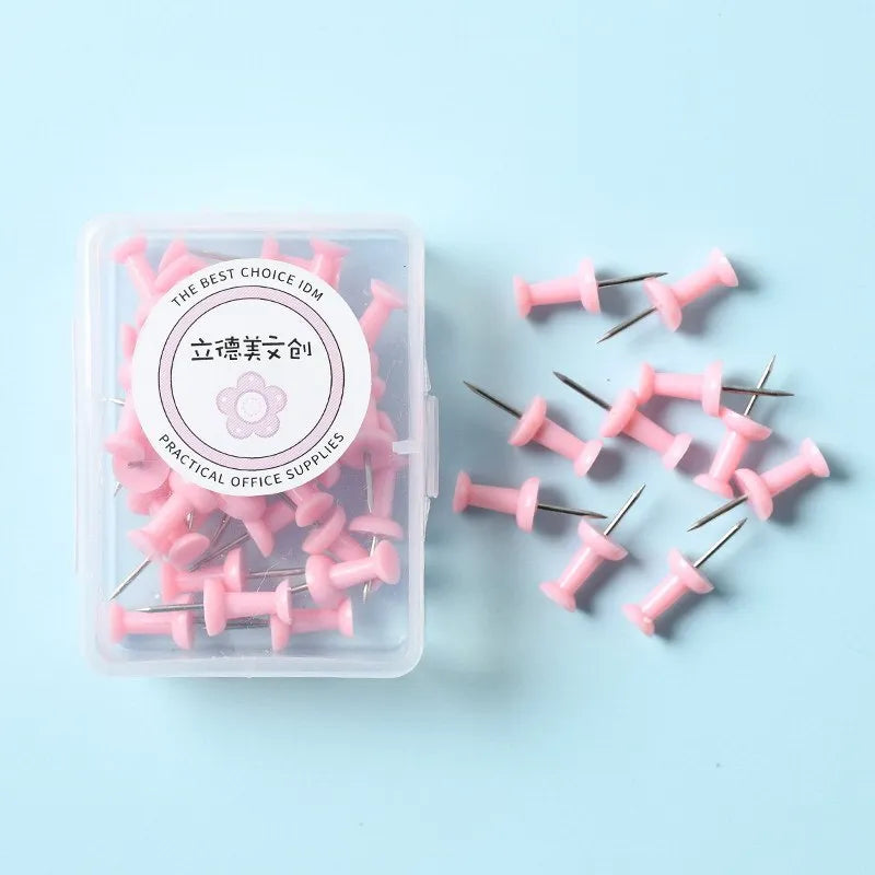 Plastic push pins in mint green, lavender, and pink, showing large and small sizes in a small box.