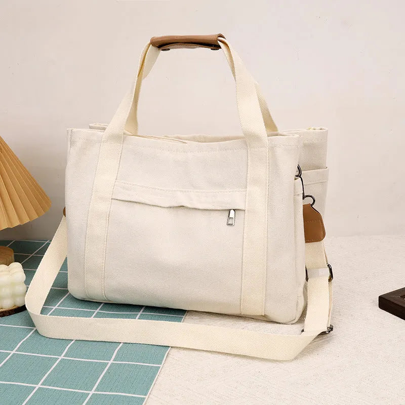Canvas tote bag showing multiple internal compartments and both sides zipper openings in horizontal square shape