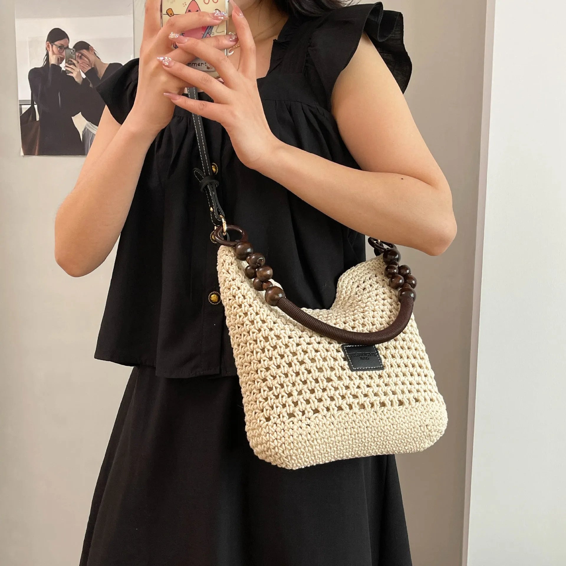 Knitted tote beach bag in bucket shape with crossbody strap showing contrast stitching details