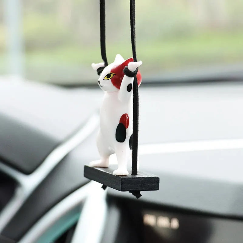 Resin cartoon cat pendant for car interior decoration on adjustable rope.