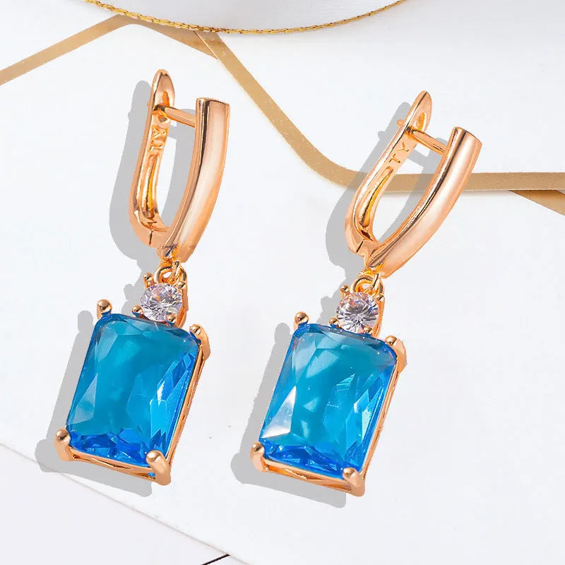 A pair of square geometric earrings with a quadrilateral design in a gold or silver electroplated finish.