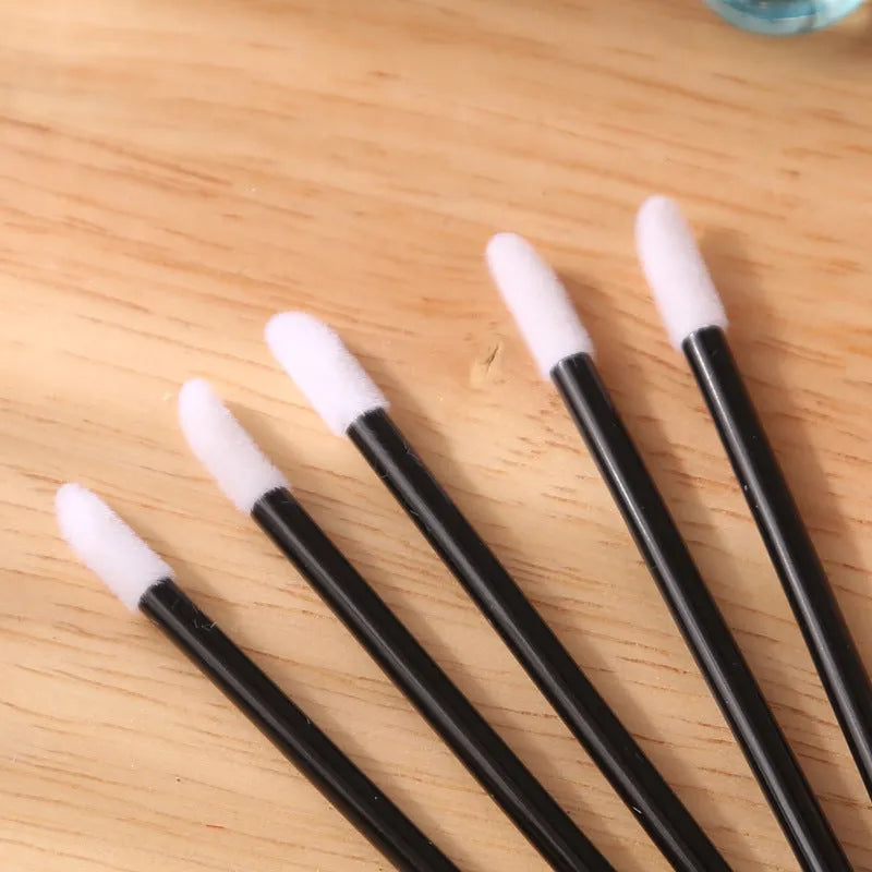 Pack of disposable lip brush wands with flocked brush tips and coloured handles.