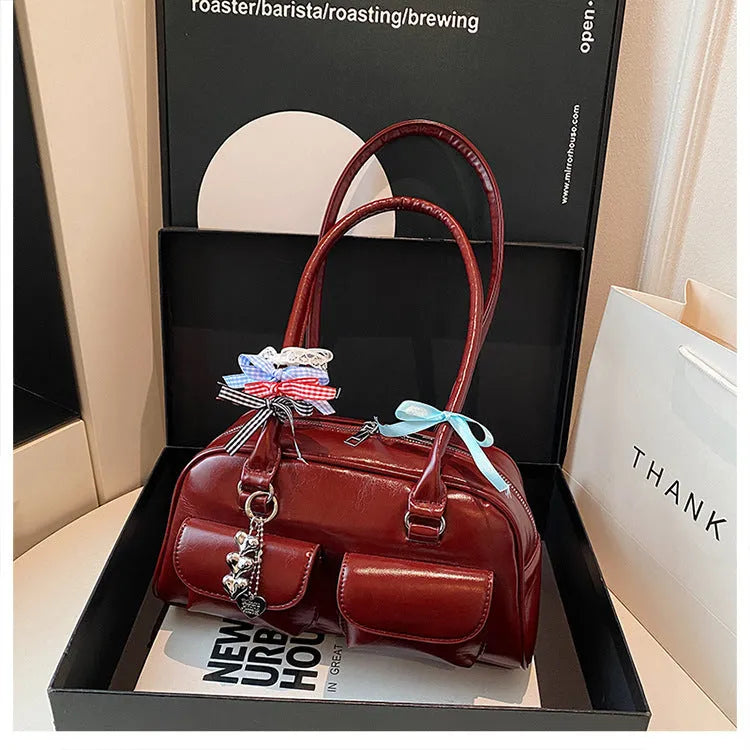 Retro one-shoulder pillow handbag in PU leather, shown in black with a flap closure and double straps.