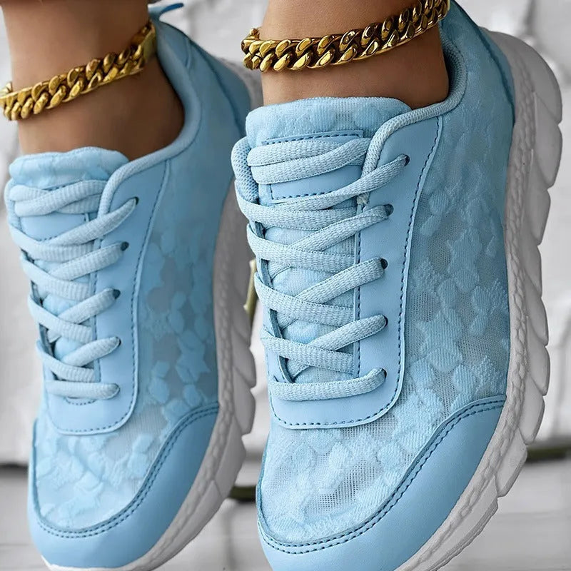 Women's white canvas running shoe with flat heel and soft sole on a light background.