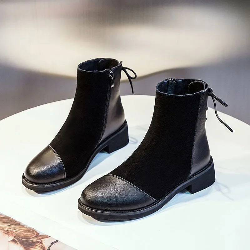 Black women's knee-high martin boots with a side zipper, round toe, and decorative bow.
