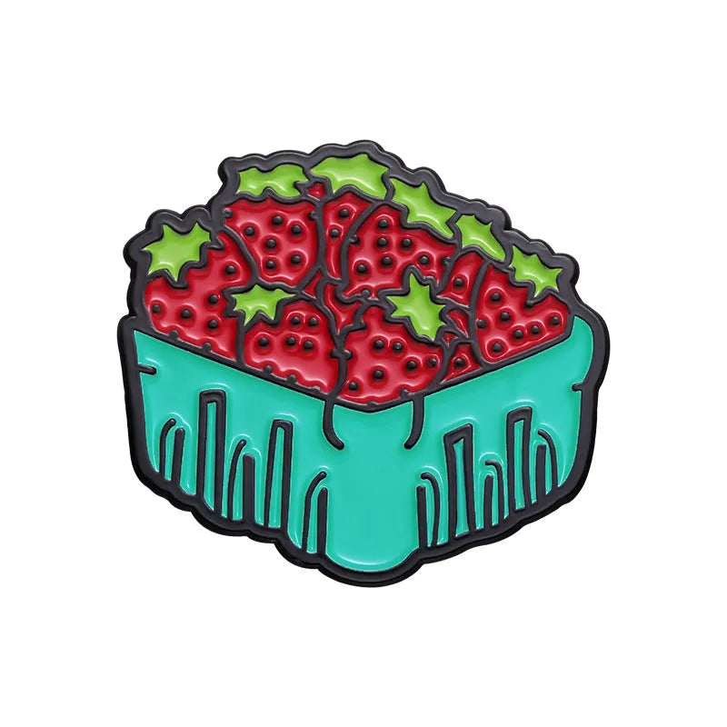 Colourful cartoon fruit design metal brooch with pin back on a fabric background.
