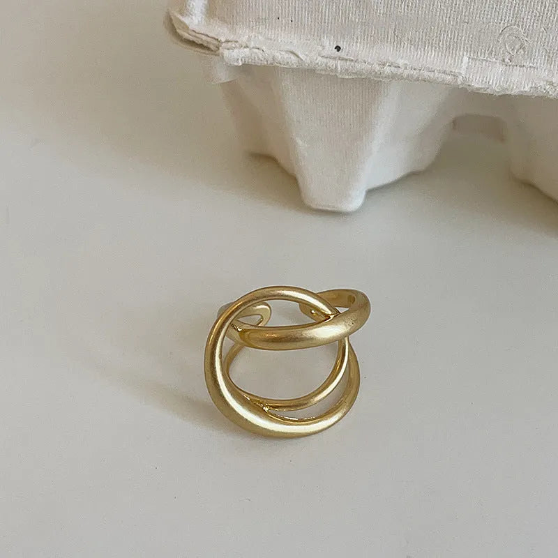 Geometric open ring with interlaced matte metal design in gold or silver electroplated finish