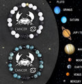 Two natural stone beaded zodiac bracelets with adjustable strings on wooden surface