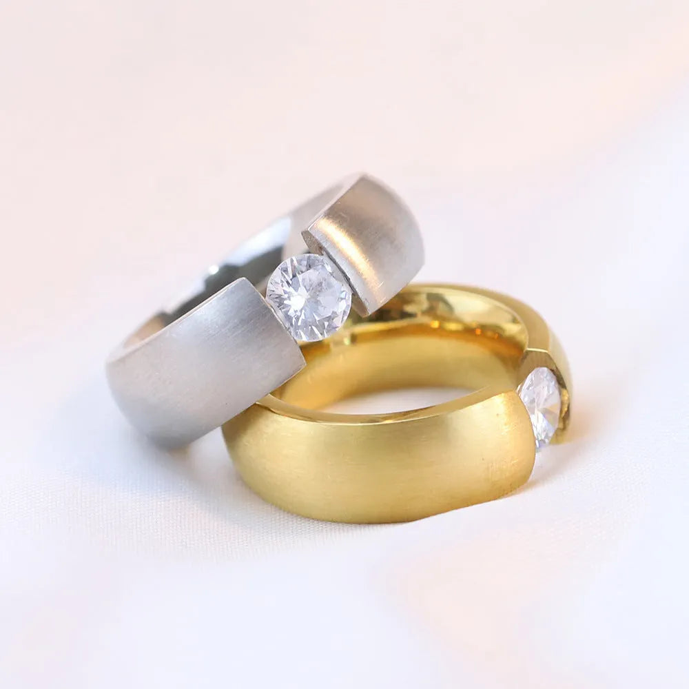Geometric titanium steel ring with diamond finish in gold colour on a white background