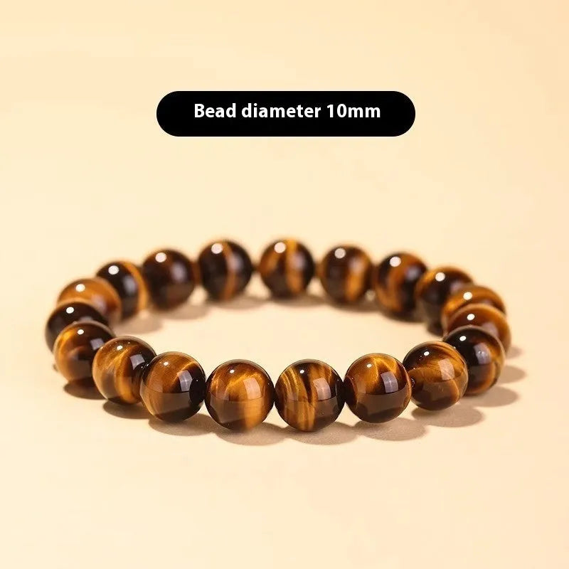 Single circle tigereye stone Buddhist prayer beads bracelet on wrist, showing ethnic design.