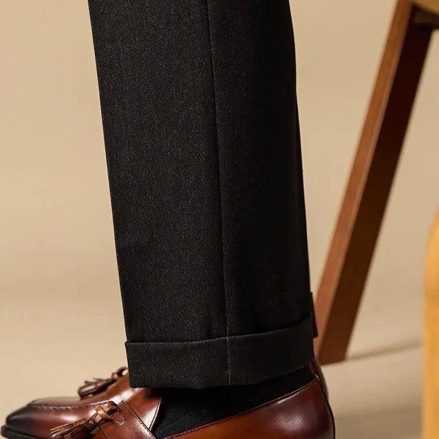 Men's black polished leather tassel loafers on a white background