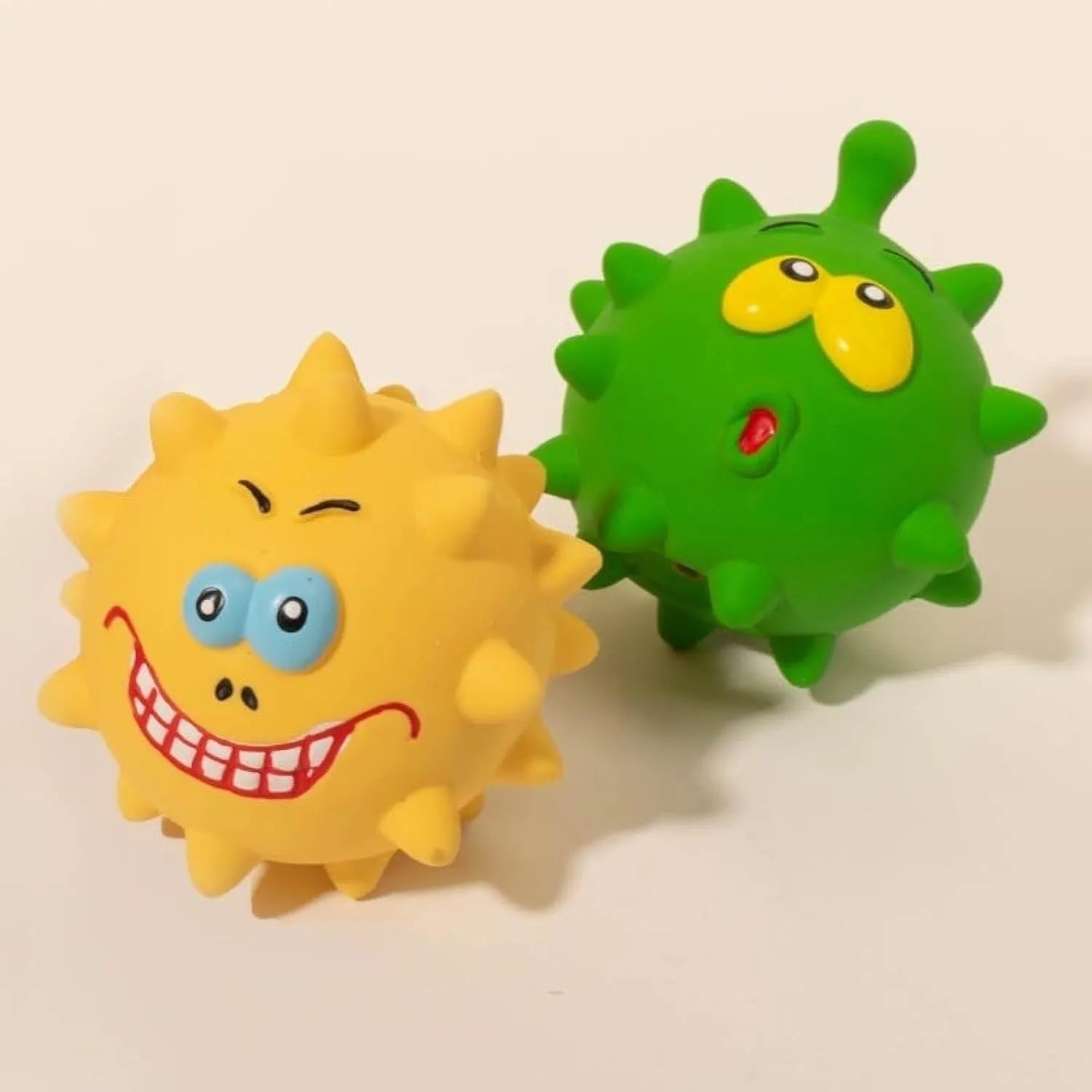 Four colourful natural latex squeaky dog balls with bumpy texture and cute faces
