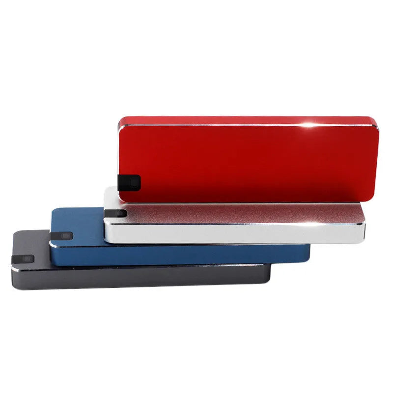 White metal portable external SSD hard drive with USB cable on a grey background