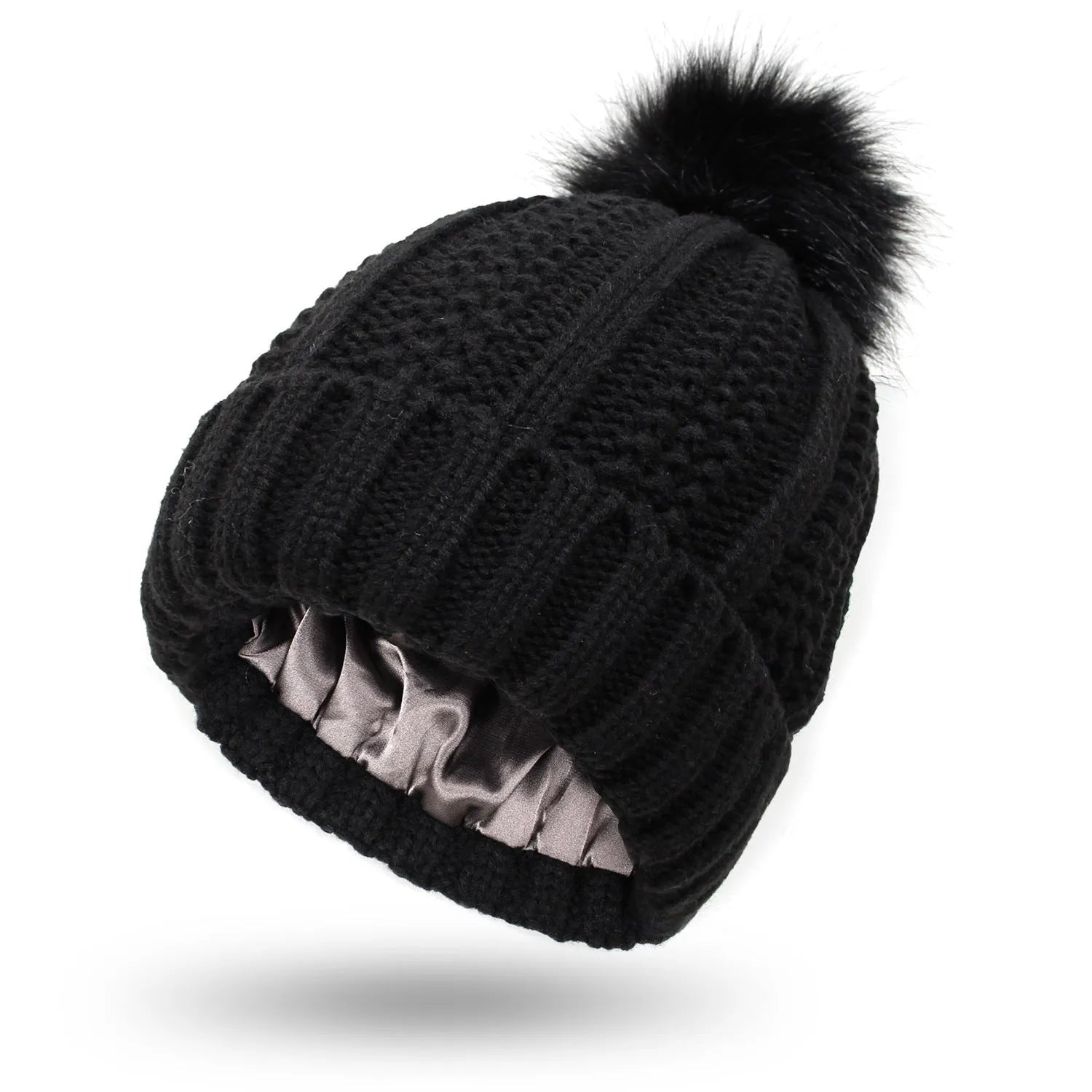 Women's black knit beanie with a faux fur pom pom and satin lining for hair protection