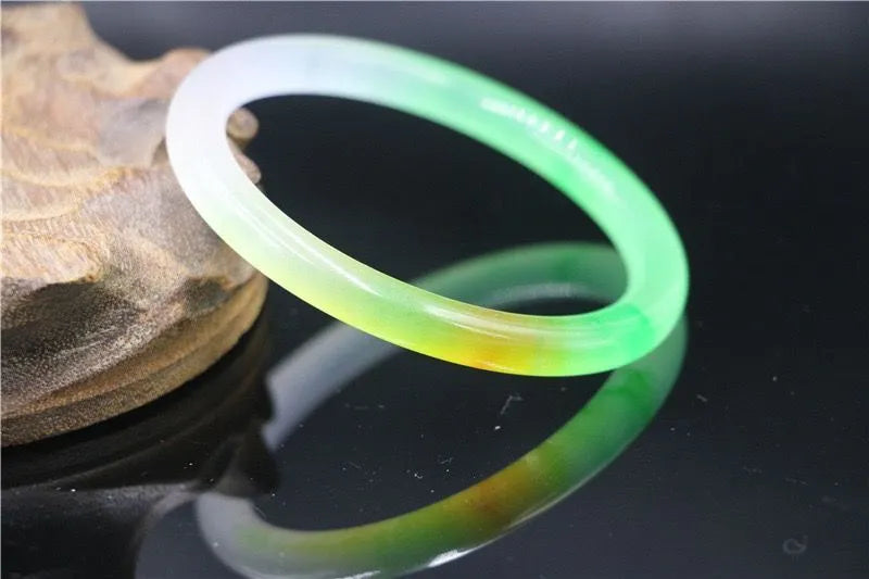 Jade bracelet with floating flower design and auspicious cloud patterns in ice-like emerald finish