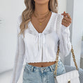 Women's short lace-up coat with hollow-out detail in black, shown in a casual streetwear setting.