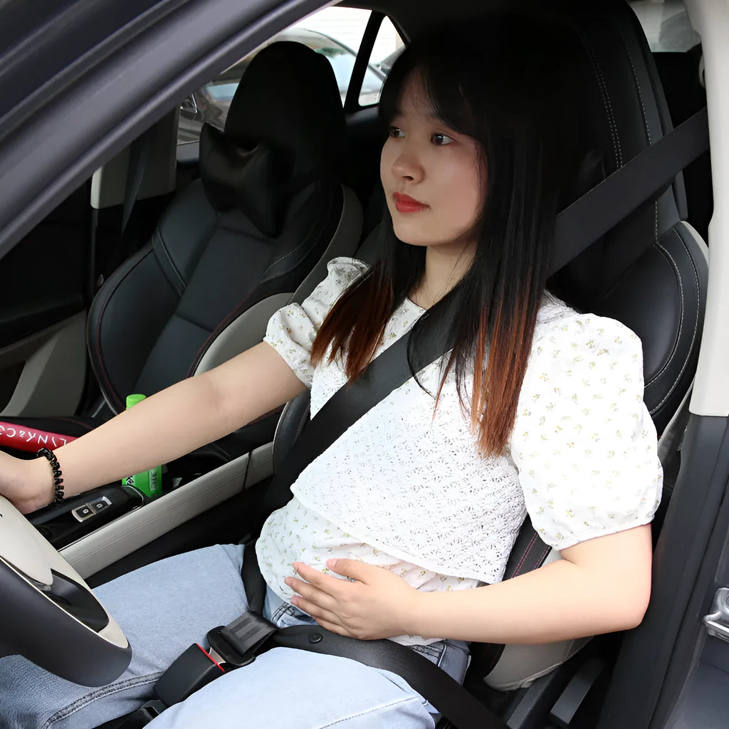 A beige press buckle maternal car seat belt support wrapped around a grey car seat.