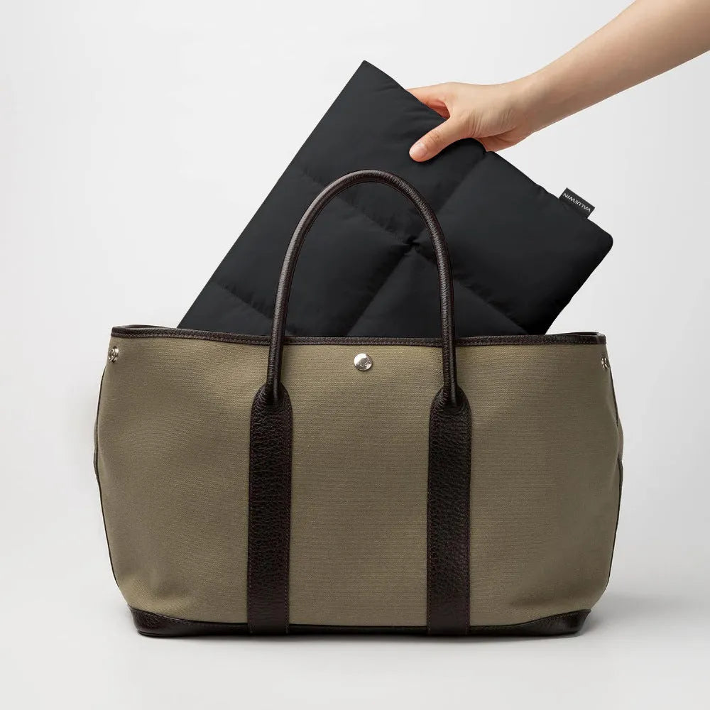 Soft black polyester laptop sleeve for a 13-15.6 inch laptop, showing fluffy texture and sewing thread detail.