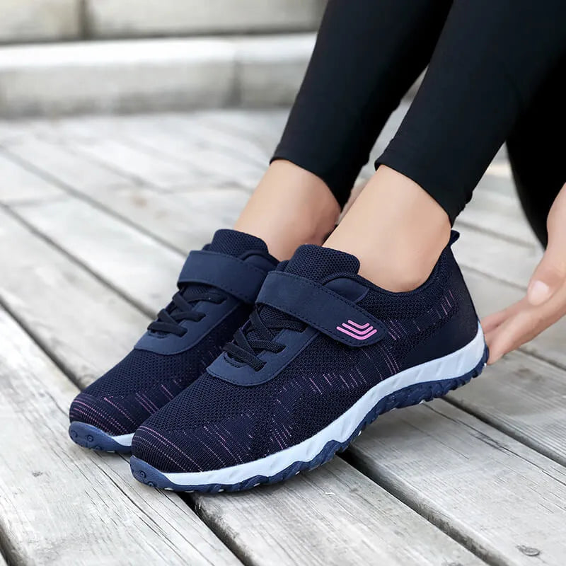Women's low-top sneakers with Velcro straps and a wedge heel, in a mesh upper and solid colour.