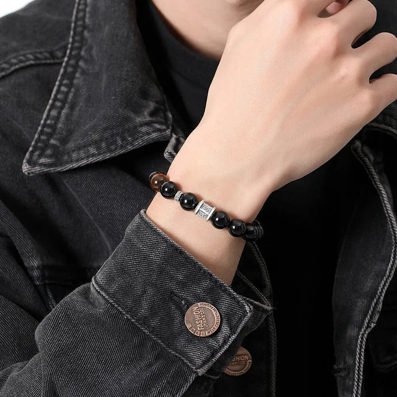 Men's obsidian prayer wheel bracelet with 10mm beads on wrist