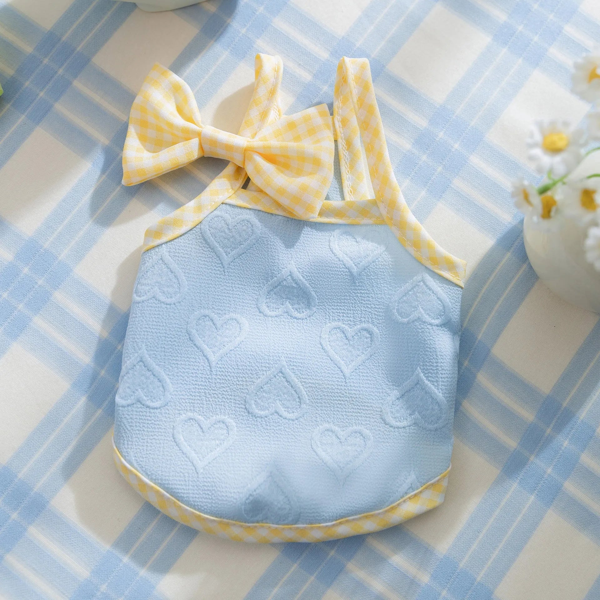Small dog wearing heart bow suspenders vest in elastic material with decorative bow detail