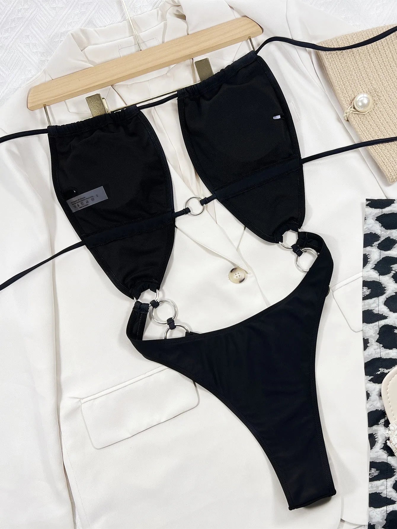 Black women's one-piece swimsuit on hanger showing sleeveless design