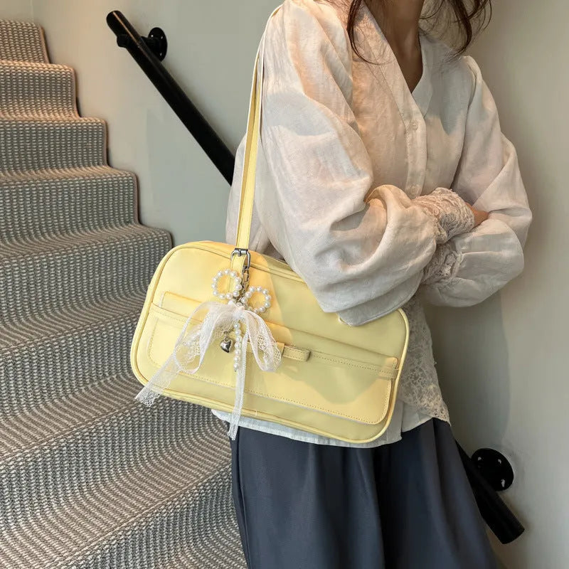 Single-shoulder flap bag in horizontal square shape with bow decoration and internal phone compartment