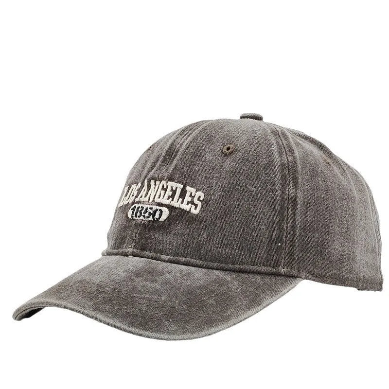 Adult personalised embroidered peaked cap in beige with adjustable strap and distressed lettering.