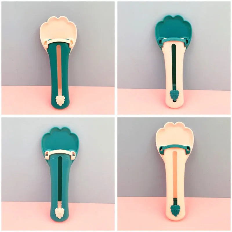 Green and pink pet food scooper spoon with squeezer handle and extruded feeder tip for dispensing treats.