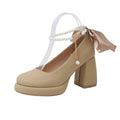 Beige women's Mary Jane shoes with a chunky heel, round toe, and ankle strap with a pearl and buckle.