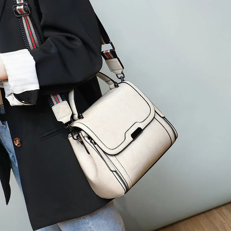 Women's brown genuine oil wax leather messenger bag showing front view with double straps and visible sewing details.