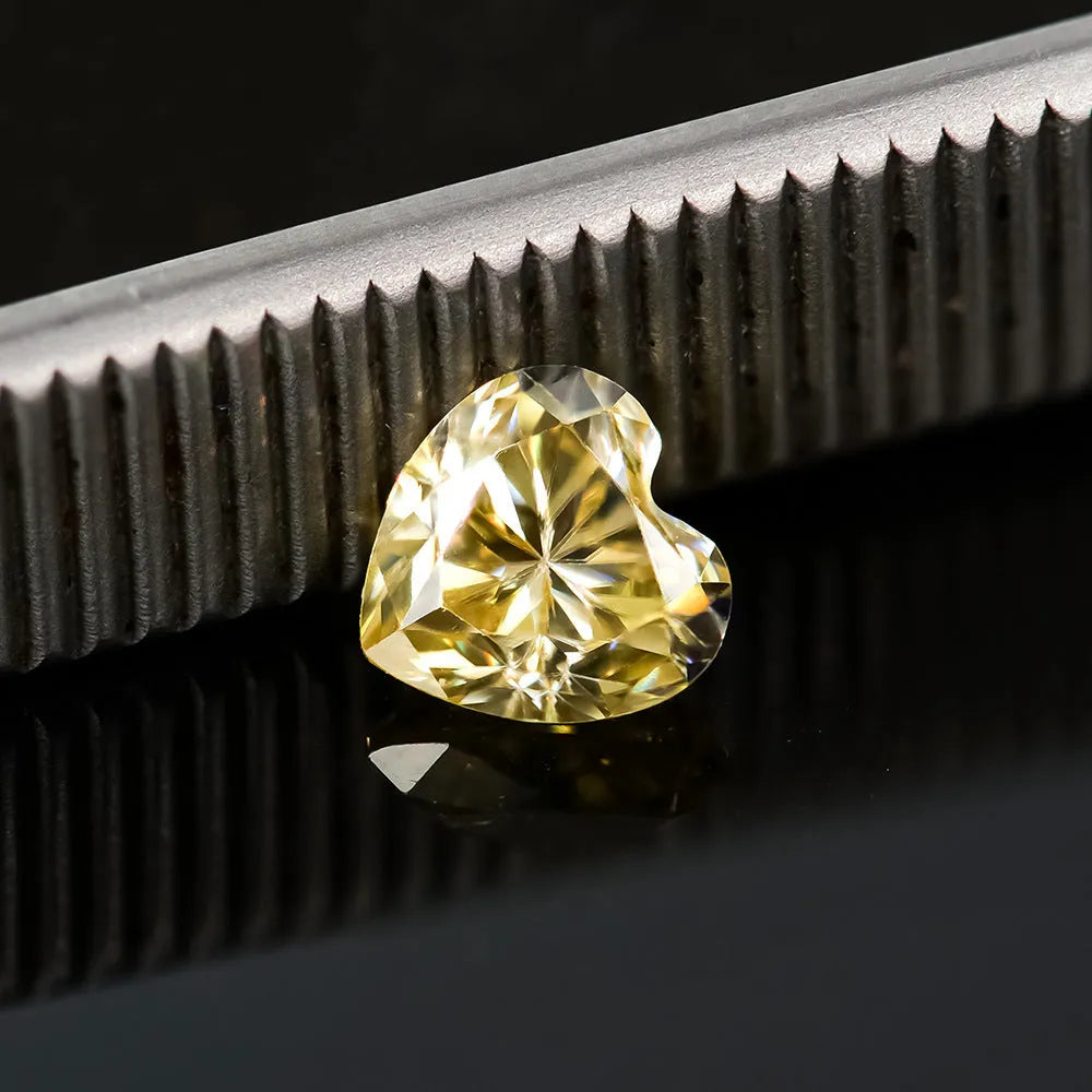 Loose lemon yellow heart-shaped moissanite stone on a plain background showing its size and cut.